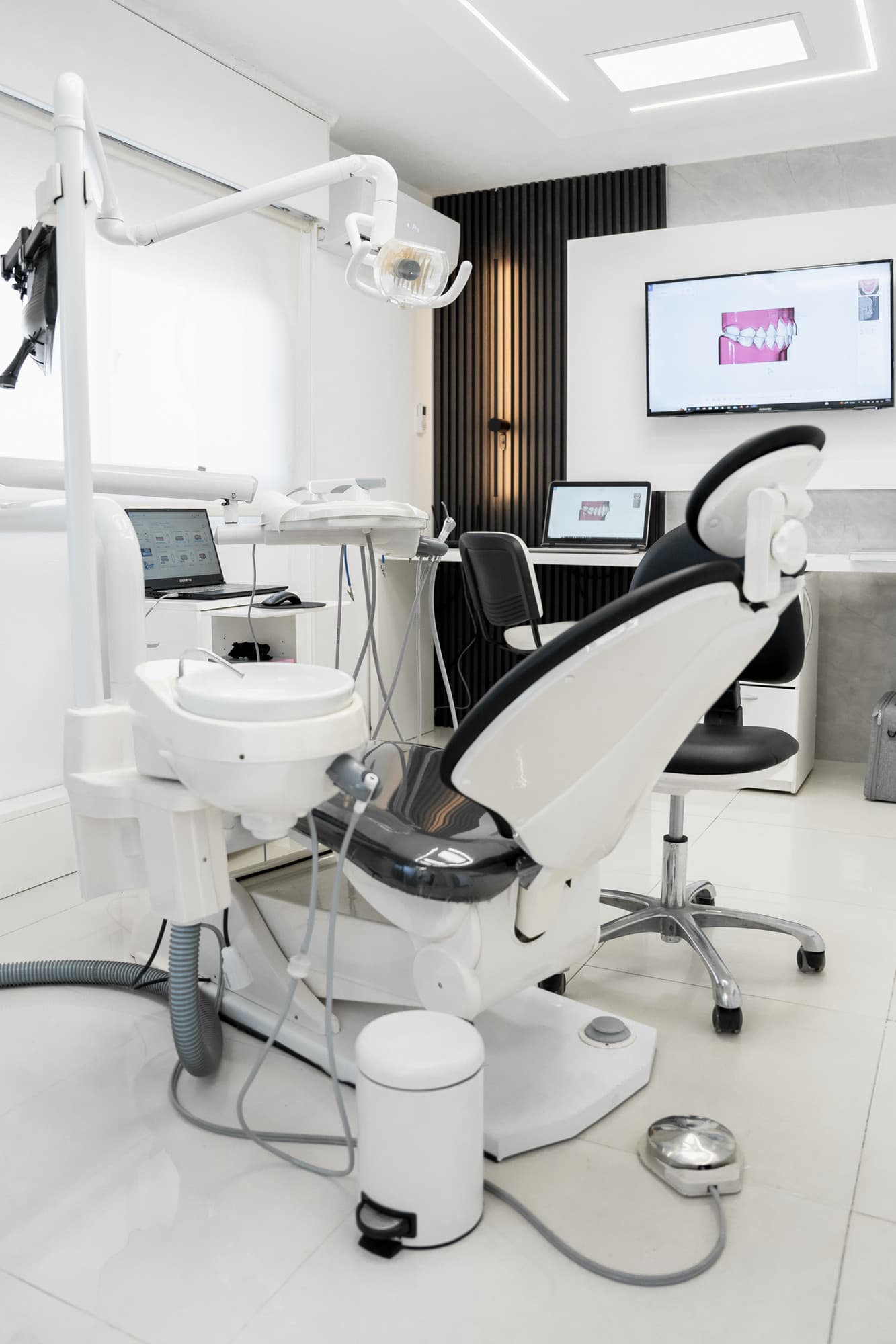 Orthodontic treatment room with a dental chair and a digital planning screen