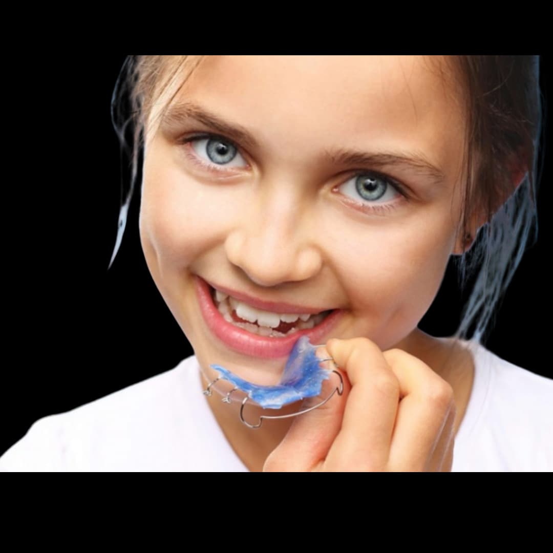 Girl smiling with a functional orthopedic appliance